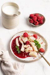 Lazy dumplings, vareniki with raspberry jam decorated with raspberry and mint leaves. Boiled cottage cheese homemade gnocchi.