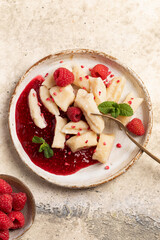 Lazy dumplings, vareniki with raspberry jam decorated with raspberry and mint leaves. Boiled cottage cheese homemade gnocchi.