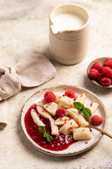 Lazy dumplings, vareniki with raspberry jam decorated with raspberry and mint leaves. Boiled cottage cheese homemade gnocchi.