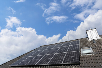 Fototapeta premium Photovoltaic panels providing green energy on a rooftop under a cloudy sky
