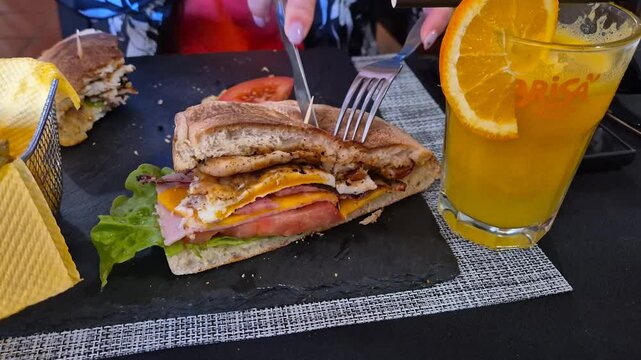 Women Slicing a Bolo de Caco Sandwich, a Traditional Madeiran Dish, Portugal