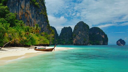 Obraz premium A lone boat sits peacefully on the shore of a sandy beach, surrounded by calm waters and warm sunlight