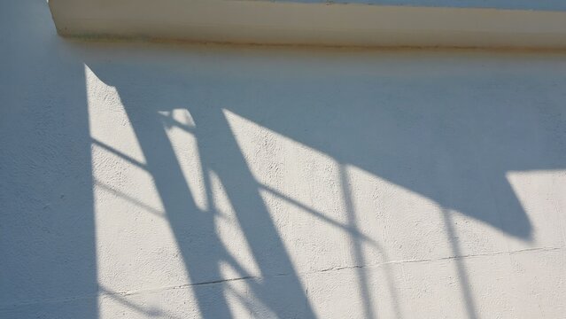 A dark shadow of a street sign on a brick wall, useful for urban or cityscape themed images