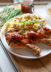 Homemade barbecue food with delicious chicken drumsticks and potato salad on a plate