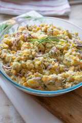 Healthy vegan potato salad with corn, pickles, red onion fresh and homemade prepared