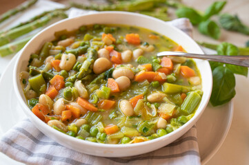 Spring vegetable soup with white beans on a plate fresh and homemade cooked