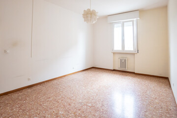 Camera con pareti bianche e lampadario