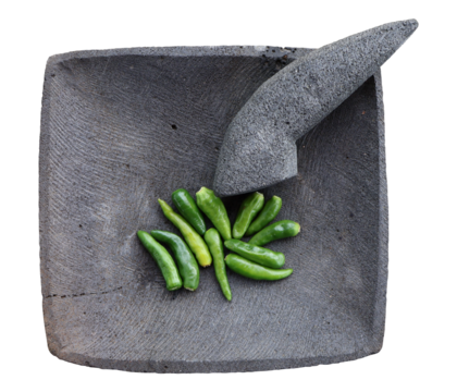 Green chilies on stone mortar and pestle