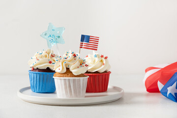Traditional American sweet cupcakes with festive stars and USA flag on white background. Dessert...