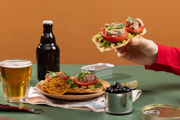 Tuna sandwiches on a table next to lemonade and beer, in a modern interior design