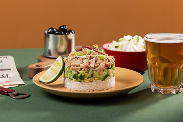 Tinned tuna salad on a plate with beer rice and other snacks in a modern interior, food art
