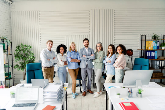 Diverse team of professionals standing together confidently in a modern office environment