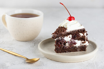 Piece of vegan brownie cake, Black forest or Schwarzwald dessert with chocolate biscuit , cream and cherries on a white table. Healthy dessert. Sugar, lactose and gluten free.