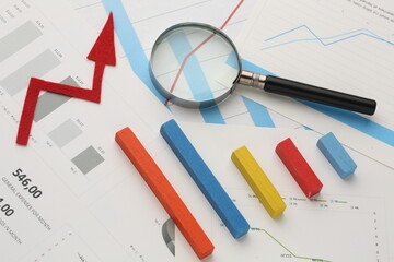 calculator and pen with blue business charts, graphs, information and reports background for...