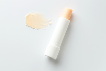 Stick of lip balm and sample on white background, top view
