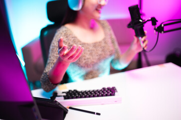 Teenager girl hosts podcast in her room using LED lights, computer, headphones, condenser...