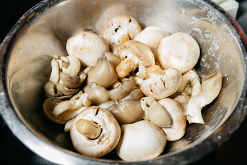 Assorted Raw Mushrooms in Metal Bowl.