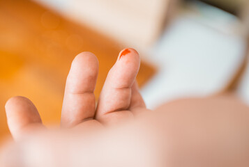 Close-up of a man's  finger cut in blood with a kitchen knife on a background. Injured finger with...