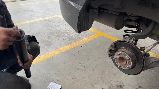 A technician is repairing the wheel section of a car