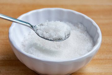 Side view of a spoon filled with coarse salt with customizable space for text or ideas.