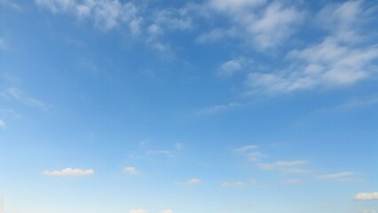 Obraz premium Light Blue Vault of Heaven, Filmy Clouds Wandering. The light blue sky is pure and vast. A few filmy clouds float leisurely, as if dancing gently, adding a touch of leisure and agility to the boundles