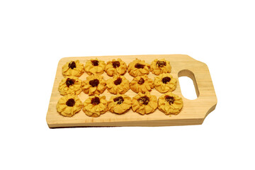 Kue semprit or Butter Cookies is a Traditional Indonesian Cookies, pineapple jam on top for Ied Al Fitr served on Wooden cutting board  and isolated on black background 