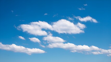 Fototapeta premium Bright blue sky filled with scattered white clouds. Keywords for uploading include sky, cloud, nature, and cloudscape.