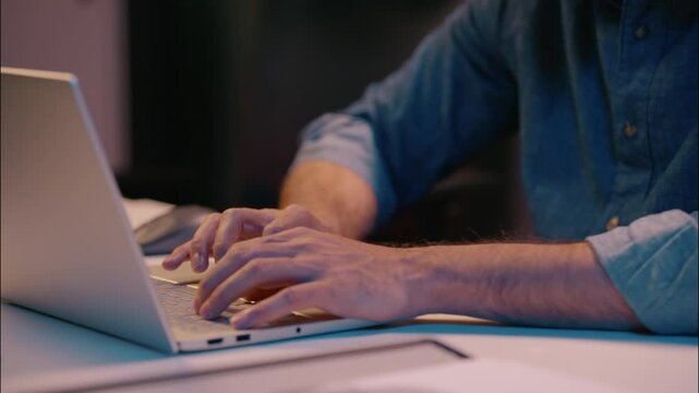Overtime night working Indian businessman male guy manager business man at dark evening office working with laptop computer browsing at desk smiling employer worker programming online commerce project