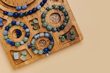 Jewelry-making board with natural stone bracelets. Assorted gemstone bracelets and raw crystals for crafting. Handmade stone bead bracelets.
