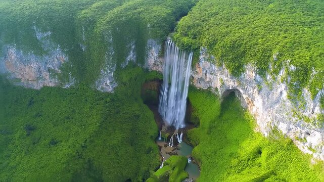Lush waterfall cascades into hidden canyon, draping emerald cliffs with flowing mist. Lush waterfall evokes tranquil wonder, fueling nature reverence. Lush waterfall invites timeless awe.
