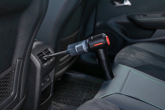 Cleaning the air vents of a car with a portable vacuum cleaner