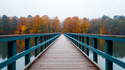 Obraz premium serene wooden bridge stretches over calm lake, surrounded by vibrant autumn foliage