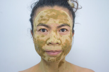 Portrait of a woman using natural skin care cream on her face