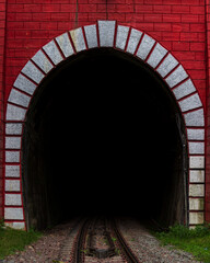 Dark tunnel with red brick wall of railroad of train.