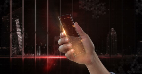 Futuristic transparent smartphone held by hand against cityscape background at night