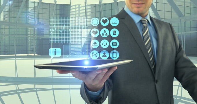 Businessman holding tablet with digital icons in modern office environment