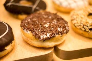Sweet temptation! Glazed donut with chocolate sprinkles on a wooden surface.