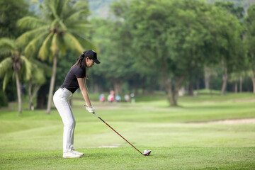 Asian woman professional golfer play golf at golf course with green golf course background, Asian...