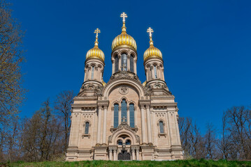 Fototapeta premium Fassade der Russisch-orthodoxen Kirche auf dem Neroberg in Wiesbaden im Sonnenlicht bei wolkenlosem, blauem Himmel