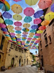 Rainbow Umbrella Sky Above Stone Buildings in Spain