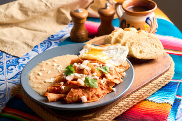 Delicious chilaquiles with fried egg and refried beans for authentic mexican breakfast