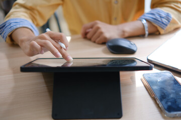 Male web designer drawing with graphic tablet at table in office.