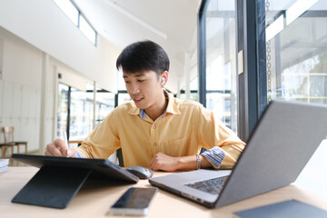 Fototapeta premium Student studying online and preparing for exams with digital devices and books