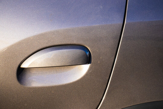 Close-up of car door handle with metallic gray-blue paint in Brazil. Showcases modern automotive design, ideal for automotive, design, and technology theme