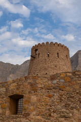 Naklejka premium Oman, 03-04-2025: the Al Qala Fort against the mountain in Bukha, a fishing village in the Musandam Peninsula (Ruus Al Jibal), the northeastern point of Arabian Peninsula south of the&nbsp;Strait of Hormuz