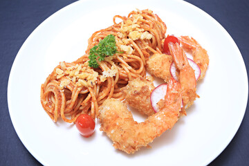 Spaghetti with Tomato Cream Sauce and Fried Shrimps served on a white plate, Thai-Italian style fusion food