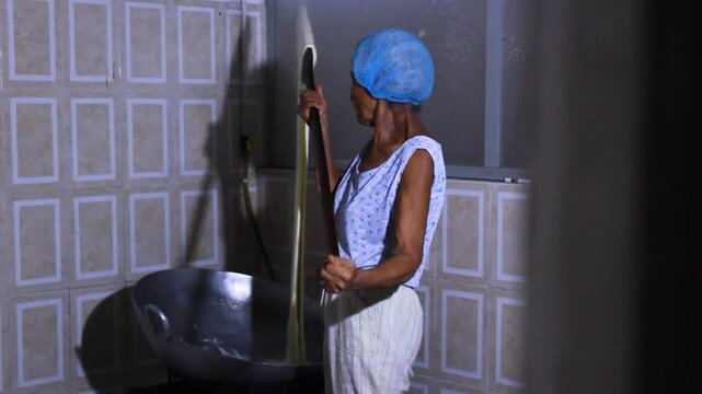 A latina woman mixing a milk drink in a pot to prepare the typical Quesillo Yaguare&ntilde;o in Yaguara, Huila, Colombia. Colombian food concept