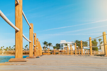 Obraz premium Wooden pier on sea stretching into distance beyond horizon on sunny summer day. Vacation and Travel Concept.