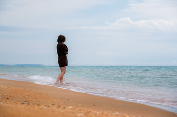 beautiful lonely girl on the beach. young woman secluded on a deserted beach, enjoying rest and...