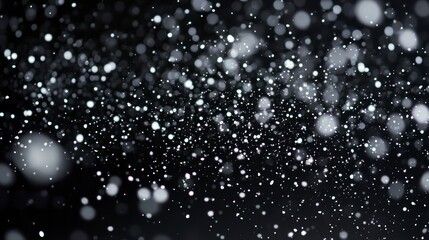 Abstract background with many tiny white and grey particles floating in the dark.